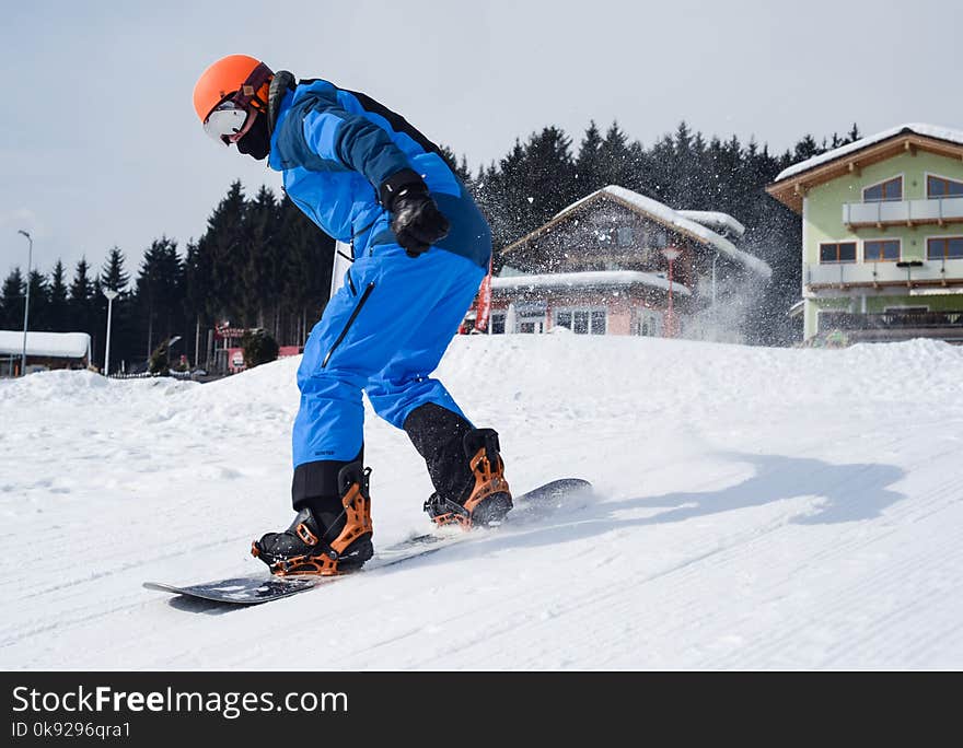 Person in Blue Coveralls Snowboarding on Snow