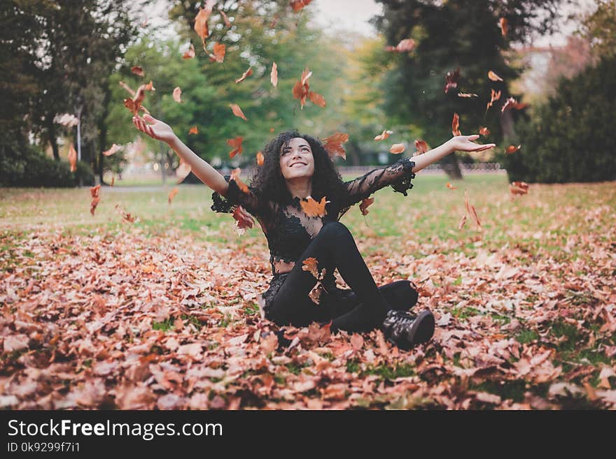 Woman Siting on Dried Leaves