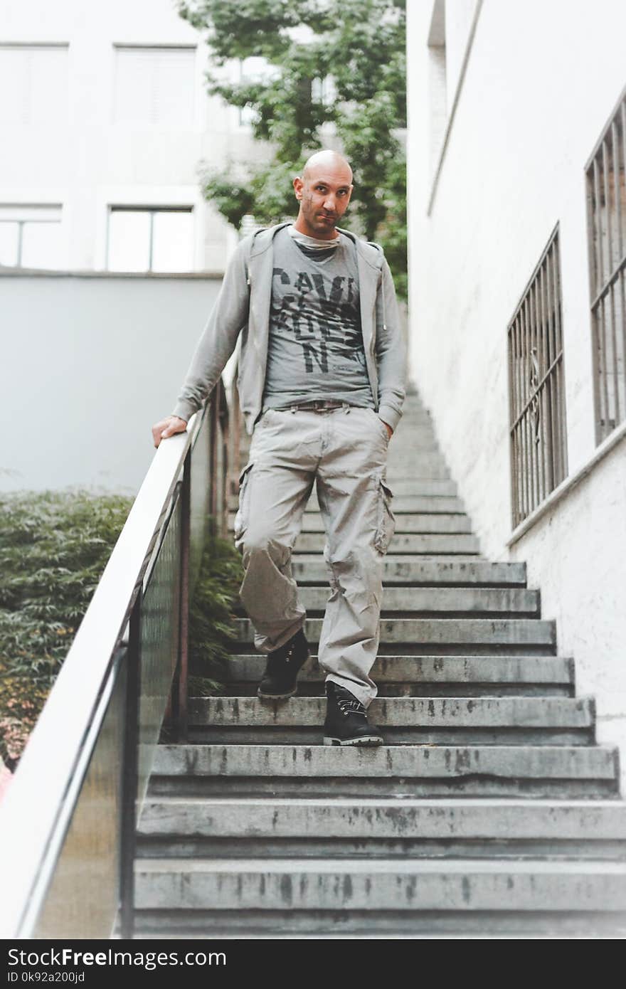 Man Wearing Gray Jacket Standing on Stair