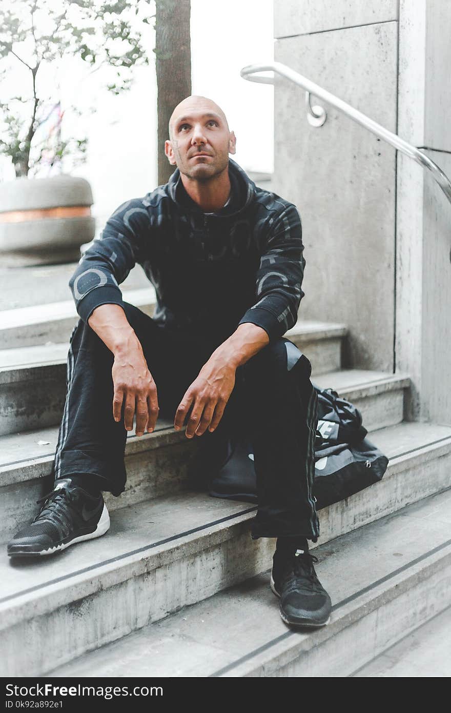 Man Sitting on Concrete Stair Looking Up