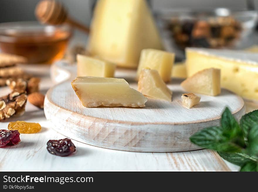 Fresh Greek cheese graviera and a slice on white wooden board