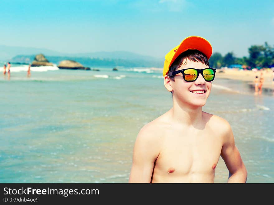 Portrait of positive joyful guy in colorful mirror sunglasses. Summertime concept. Portrait of positive joyful guy in colorful mirror sunglasses. Summertime concept