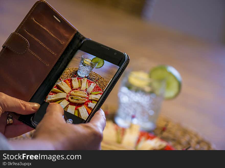 A woman using a smartphone to capture her meal for social media. A woman using a smartphone to capture her meal for social media