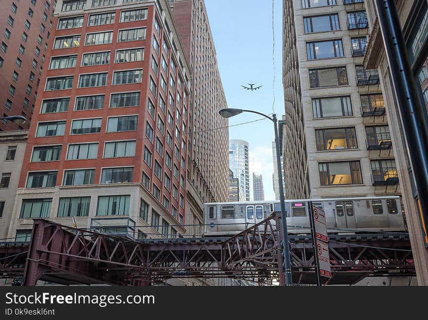 Train passing by in downtown Chicago and airplane flying overhead, shot in 2018