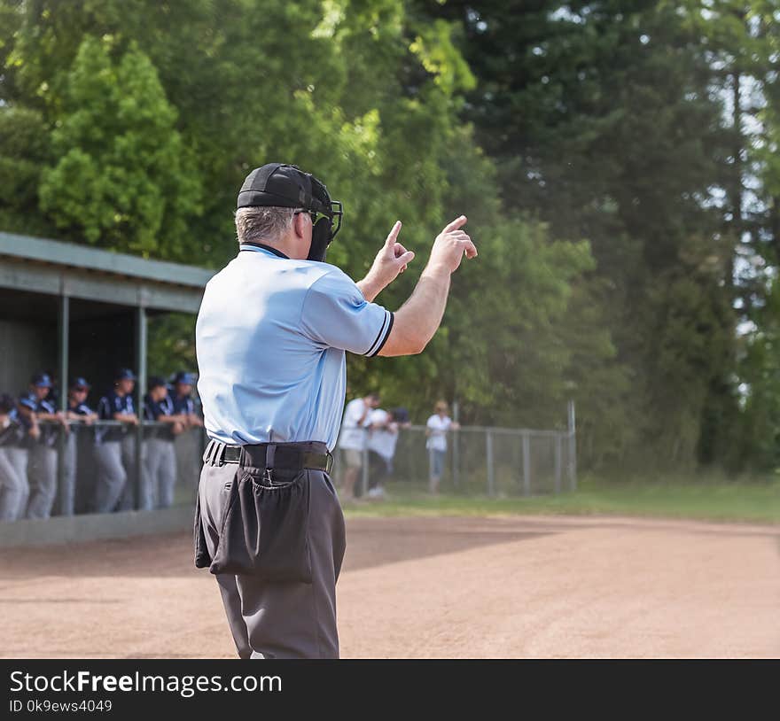 Umpire calls one ball, one strike , players in dugout in background