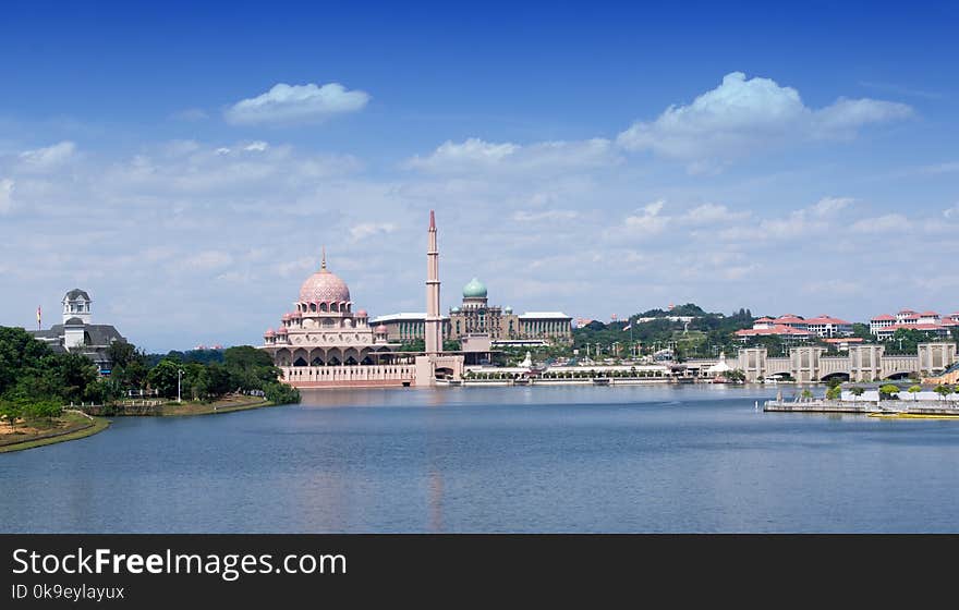 Landscape view of Putra mosque and office building of the prime minister at Putrajaya, Malaysia during morning. Landscape view building with lake, sky white cloud nature composition.