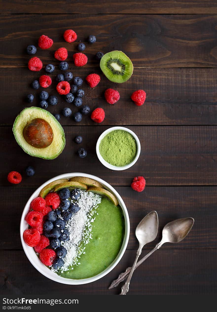 Healthy Green Smoothie Bowl on a Rustic Wooden Surface Shot from Overhead. Healthy Green Smoothie Bowl on a Rustic Wooden Surface Shot from Overhead