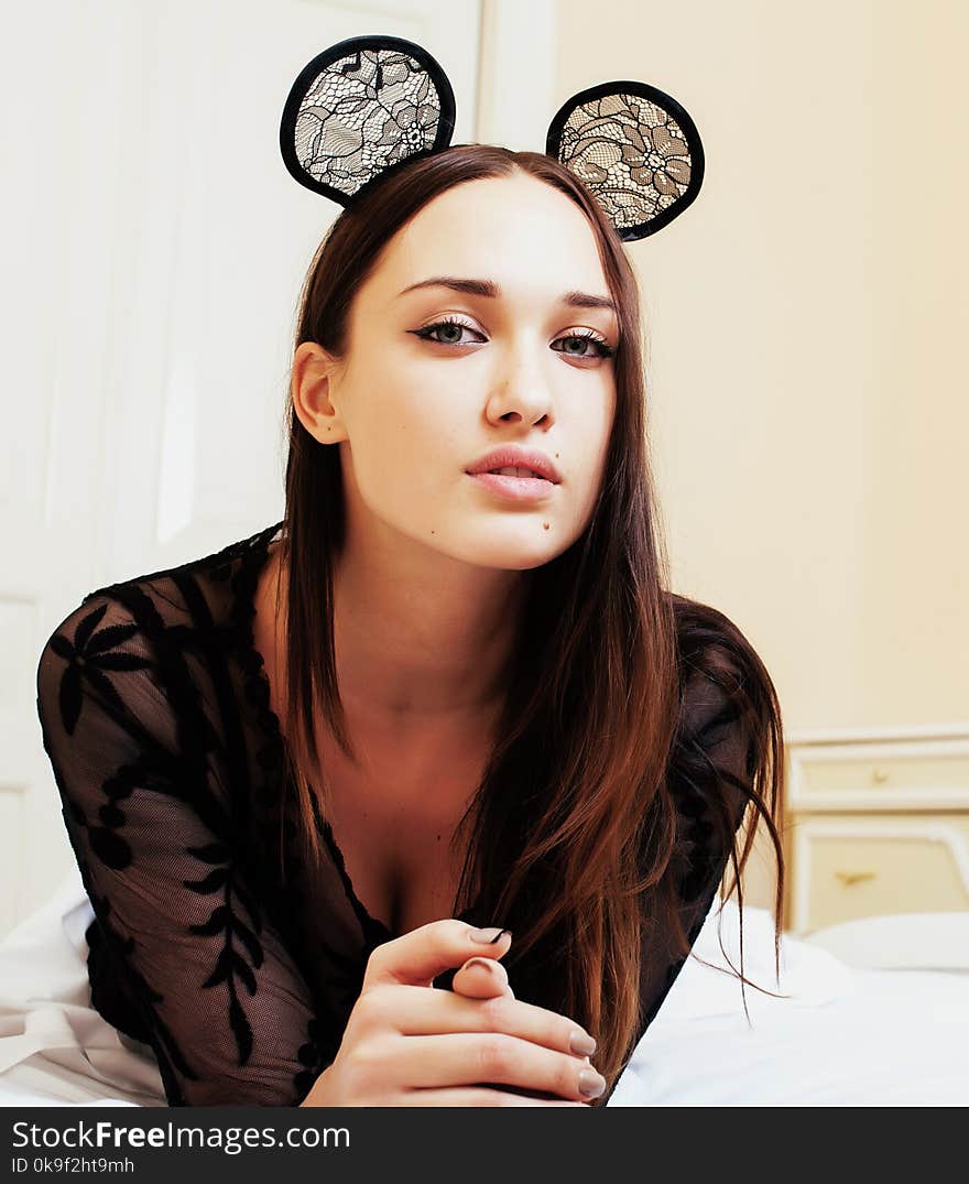 Young pretty brunette woman wearing lace mouse ears, laying waiting dreaming in bed close up, lifestyle people concept