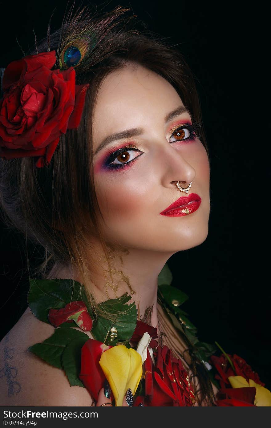 Portrait of a young attractive girl with roses. Passion and sensuality. Creative makeup. Portrait of a young attractive girl with roses. Passion and sensuality. Creative makeup.