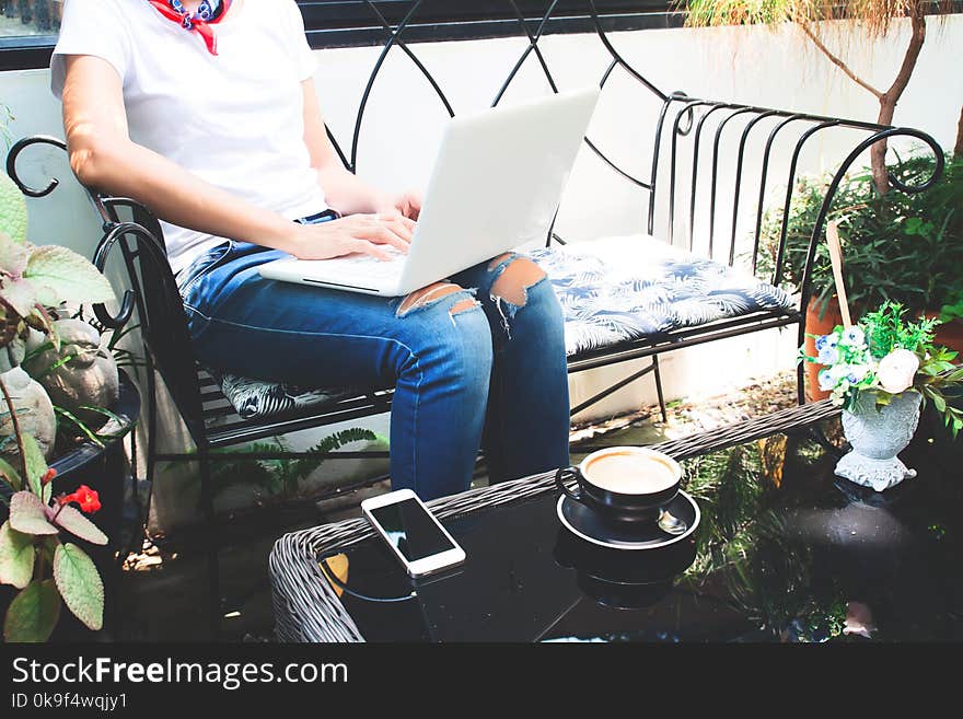 Woman in casual style clothing using laptop computer and smartphone in cafe, Online shopping or Working