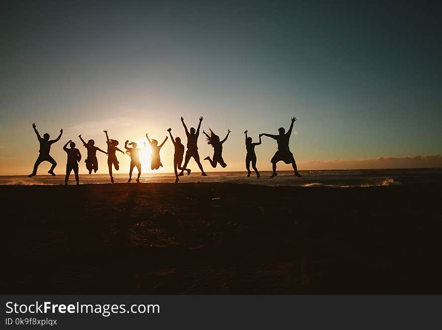 Silhouette Photography of Group of People Jumping during Golden Time