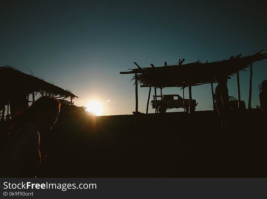 Silhouette of Pickup Truck Near Hut