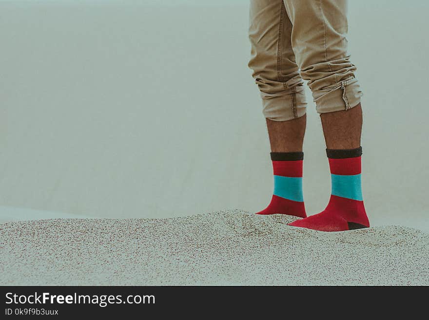 Person Wearing Red Socks Standing on Sand