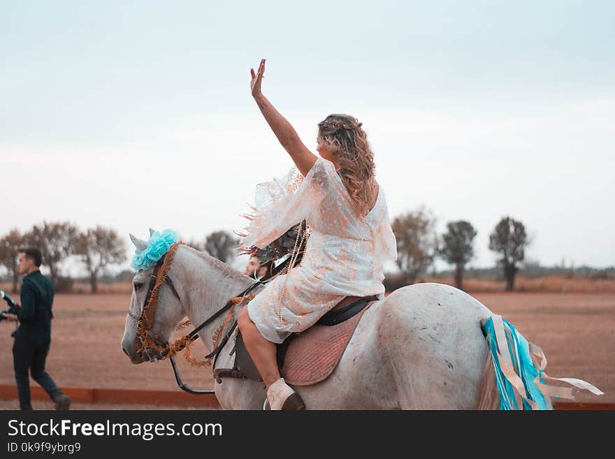 Woman Riding on White Horse