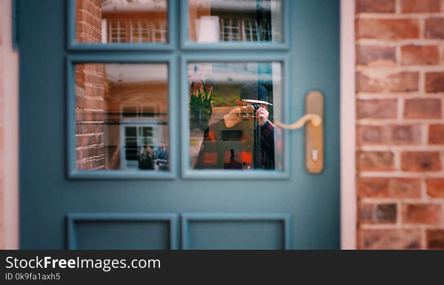 Man in Black Sweater Taking Photo of Blue Door