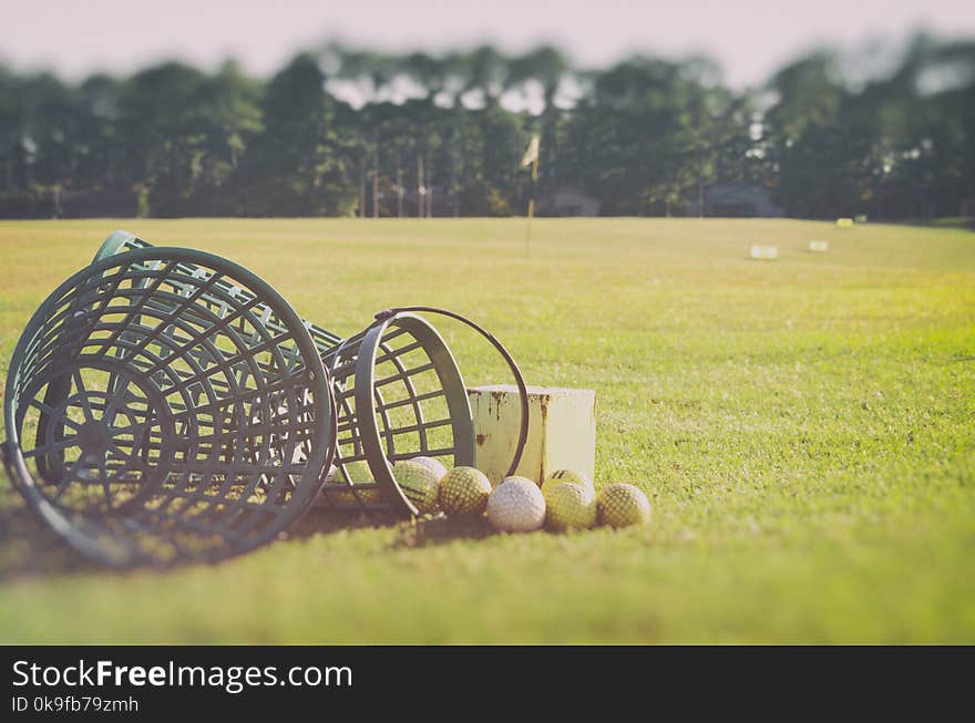 Golf at the driving range Basket with golf balls at the rough zone of course