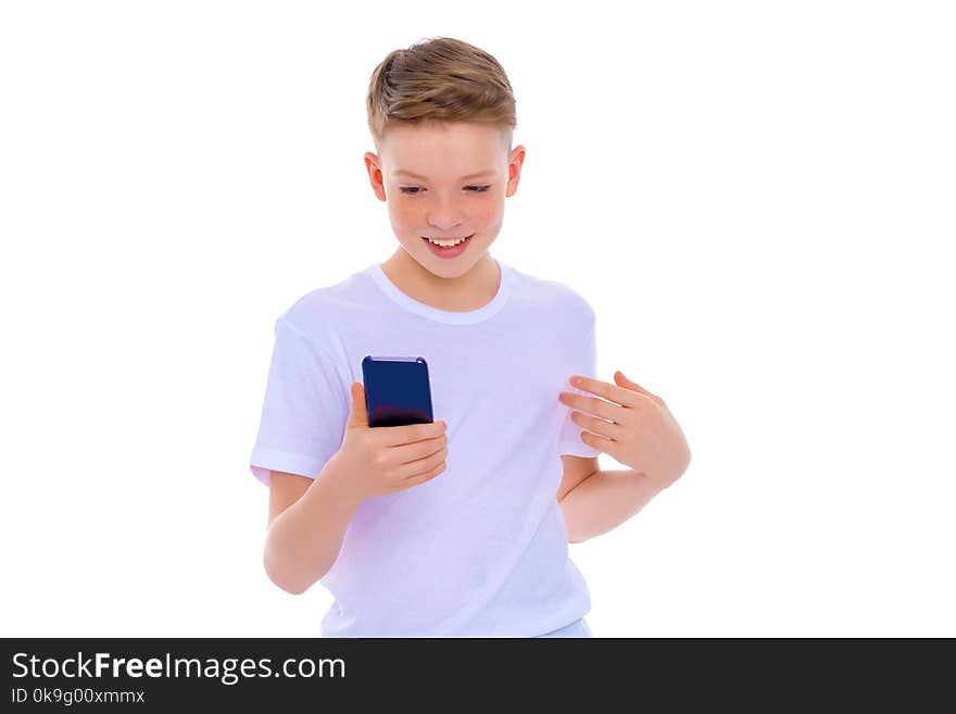 Close-up portrait.A small boy of school age uses a mobile phone. The concept of digital technology, communication between people. Isolated on white background. Close-up portrait.A small boy of school age uses a mobile phone. The concept of digital technology, communication between people. Isolated on white background.