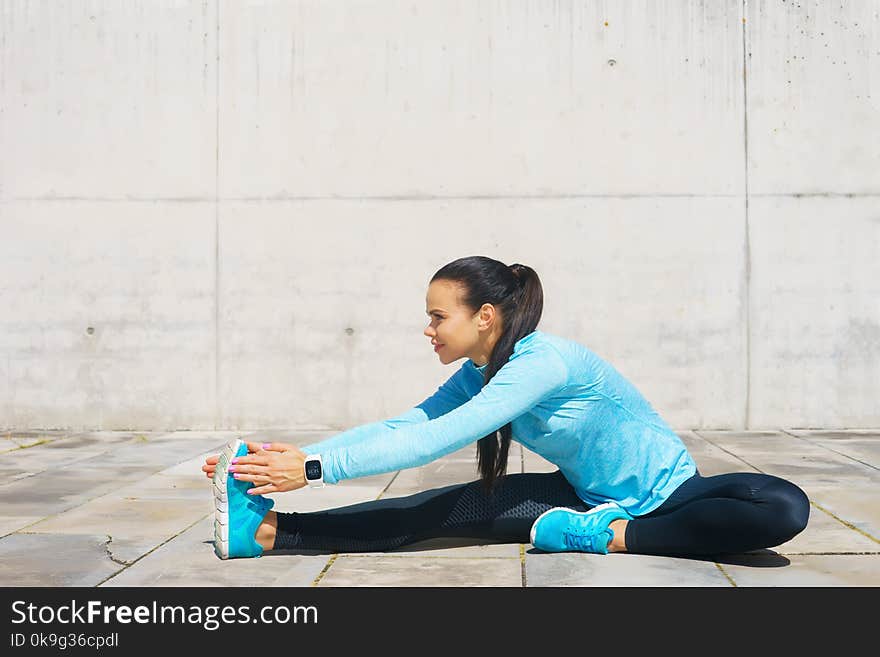 Young, fit and sporty girl stretching in the street. Fitness, sport, urban jogging and healthy lifestyle concept. Young, fit and sporty girl stretching in the street. Fitness, sport, urban jogging and healthy lifestyle concept.