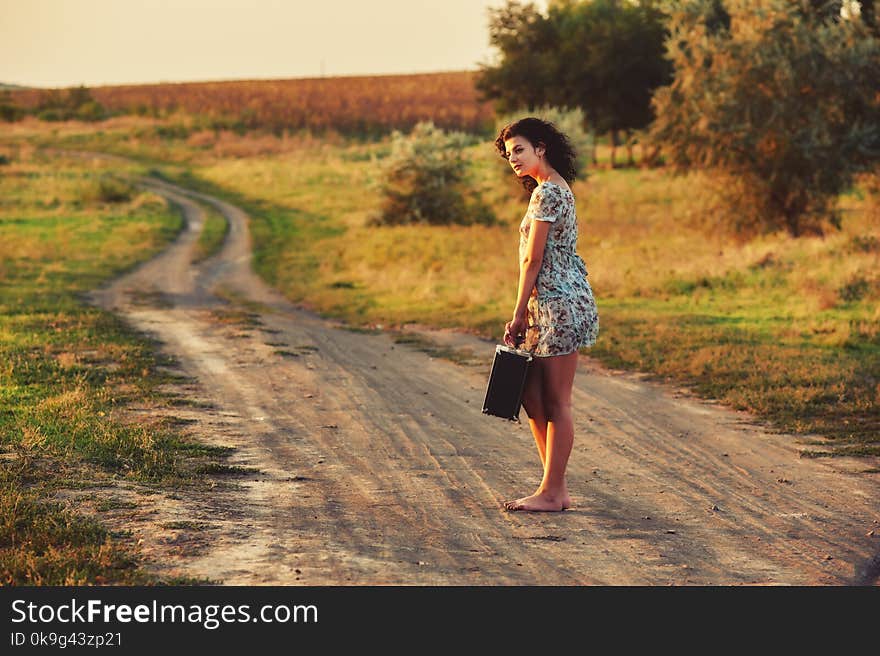 A young woman in a rural area on a country road. A young woman in a rural area on a country road