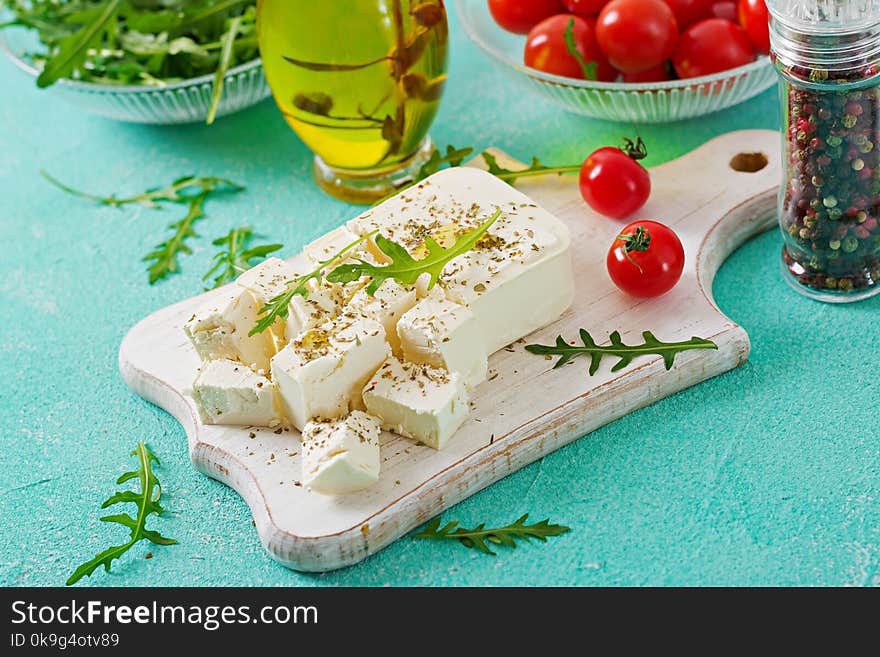 Feta cheese, cherry tomatoes and rucola on the table. Ingredients for salad