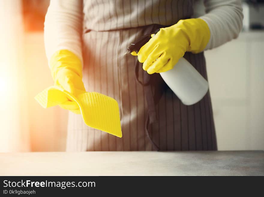 Woman in yellow rubber protective gloves wiping dust and dirty. Cleaning concept, banner, copy space.