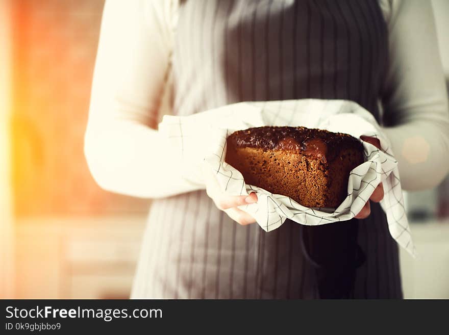 Woman hands holding freshly baked bread. Handmade brown loaf of bread, bakery concept, homemade food, healthy eating. Copy space.