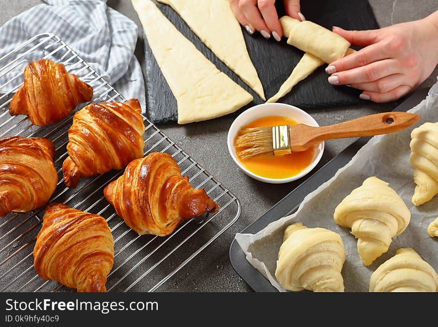 Woman is shaping dough to bake French croissants