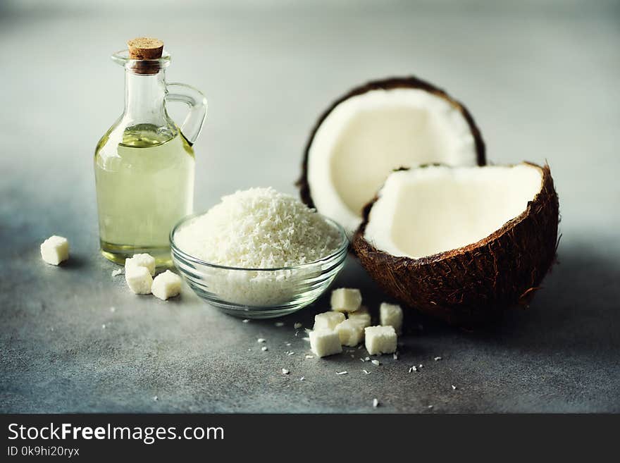 Coconuts Products - Milk, Oil, Shavings On Grey Concrete Background. Copy Space. Hair, Skin And Body Treatment.