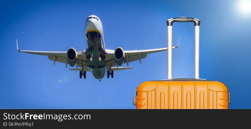 Travel concept. Suitcases and the boarding plane in the blue sky