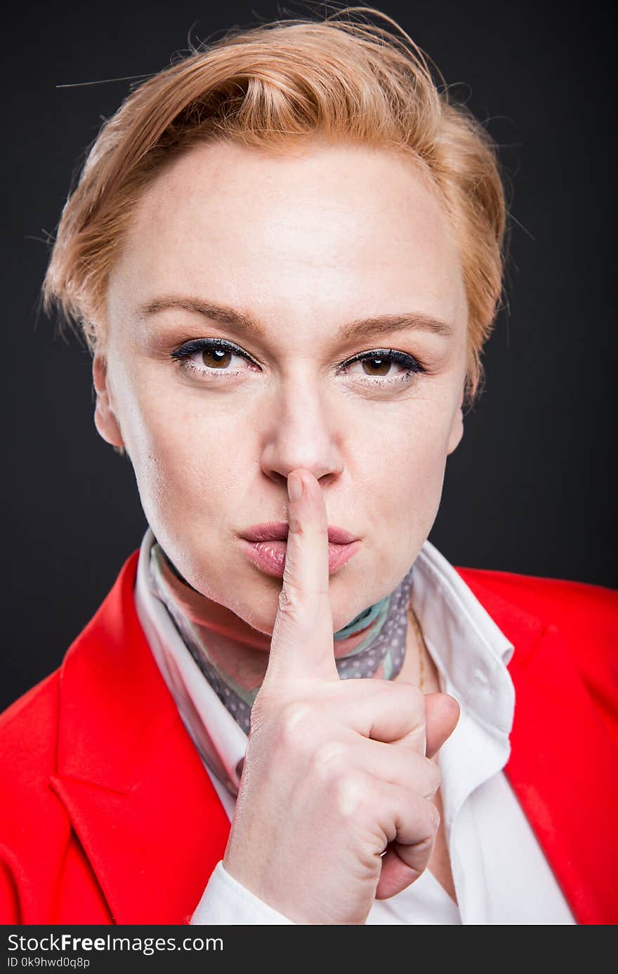 Portrait of attractive business showing sush gesture on black background