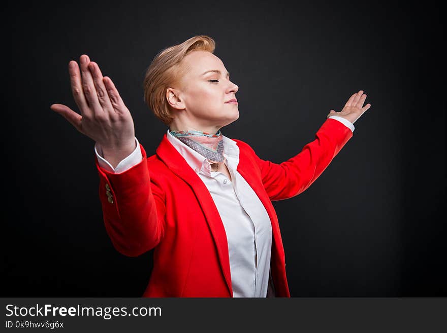 Portrait of attractive business woman holding arms spread like winner concept on black background with copyspace advertising area