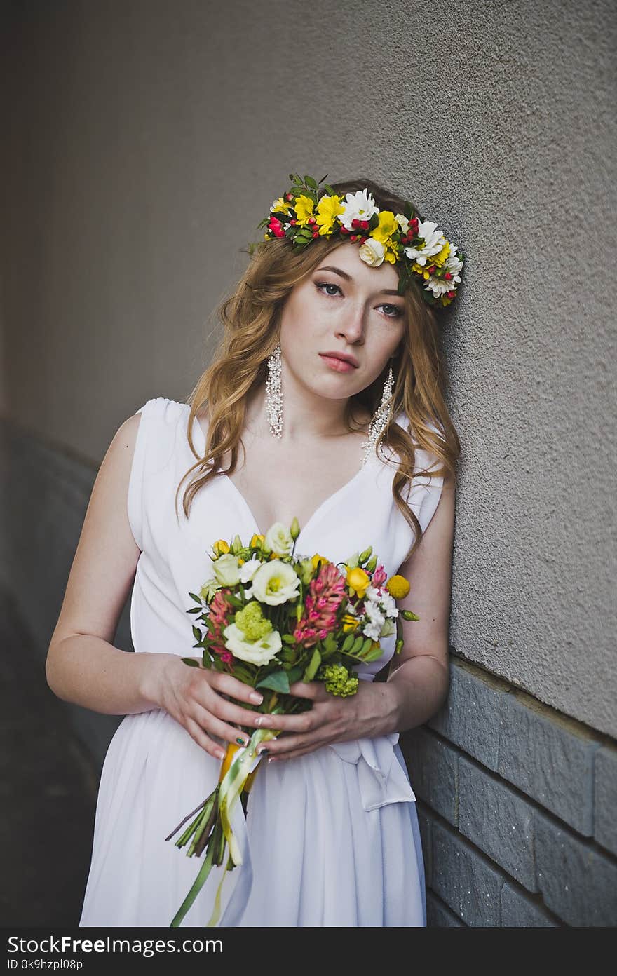 Portrait of a girl in a white dress against the wall. Portrait of a girl in a white dress against the wall.