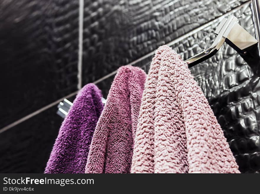 Towels of different colors hanging on a hanger in the bathroom