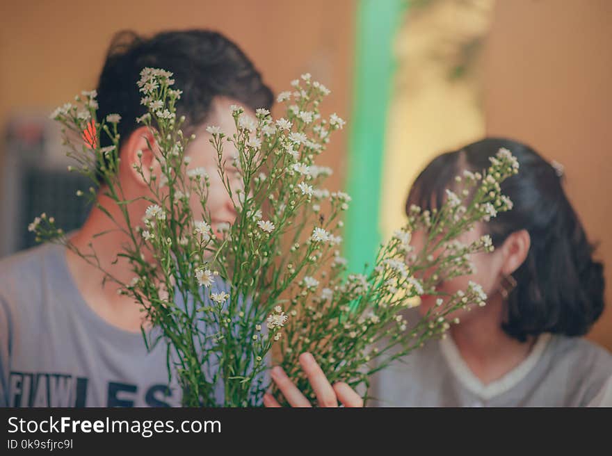 Photo of Man and Woman Behind the Flowers