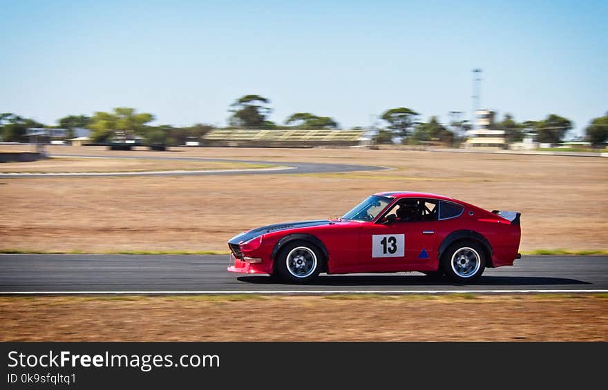 Red and Black Sports Coupe on Road at Daytime