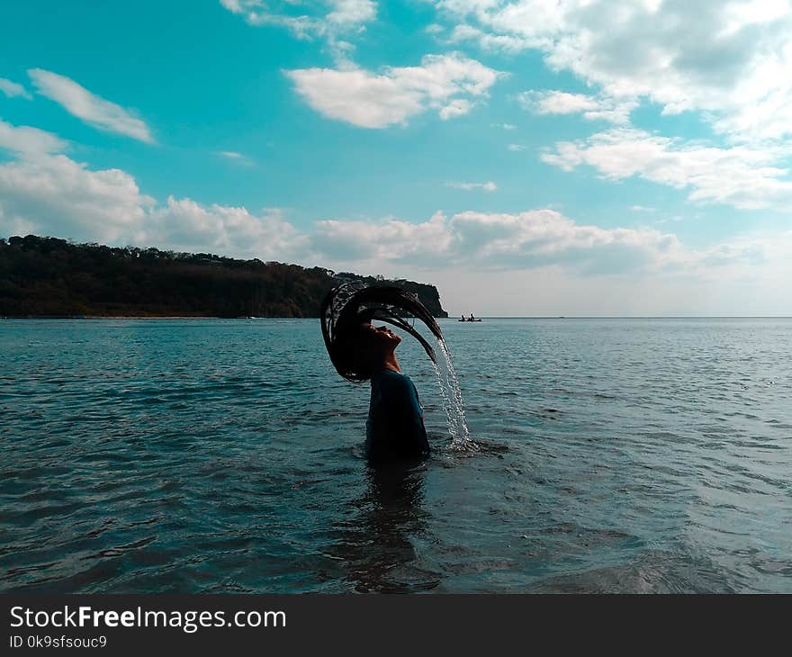 Woman in Black Shirt Lifting Her Hair from Water during Noontime