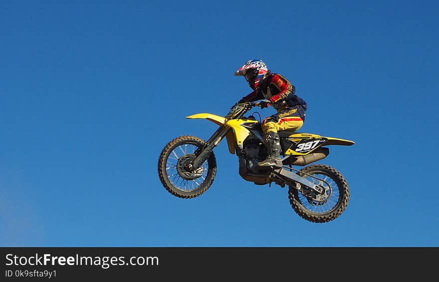 Man Riding Yellow Motocross Dirt Bike