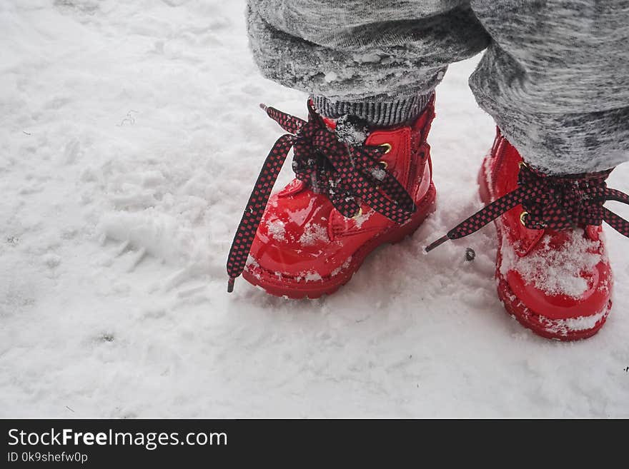 Toddler Wearing Red Shoes Standing On Snow