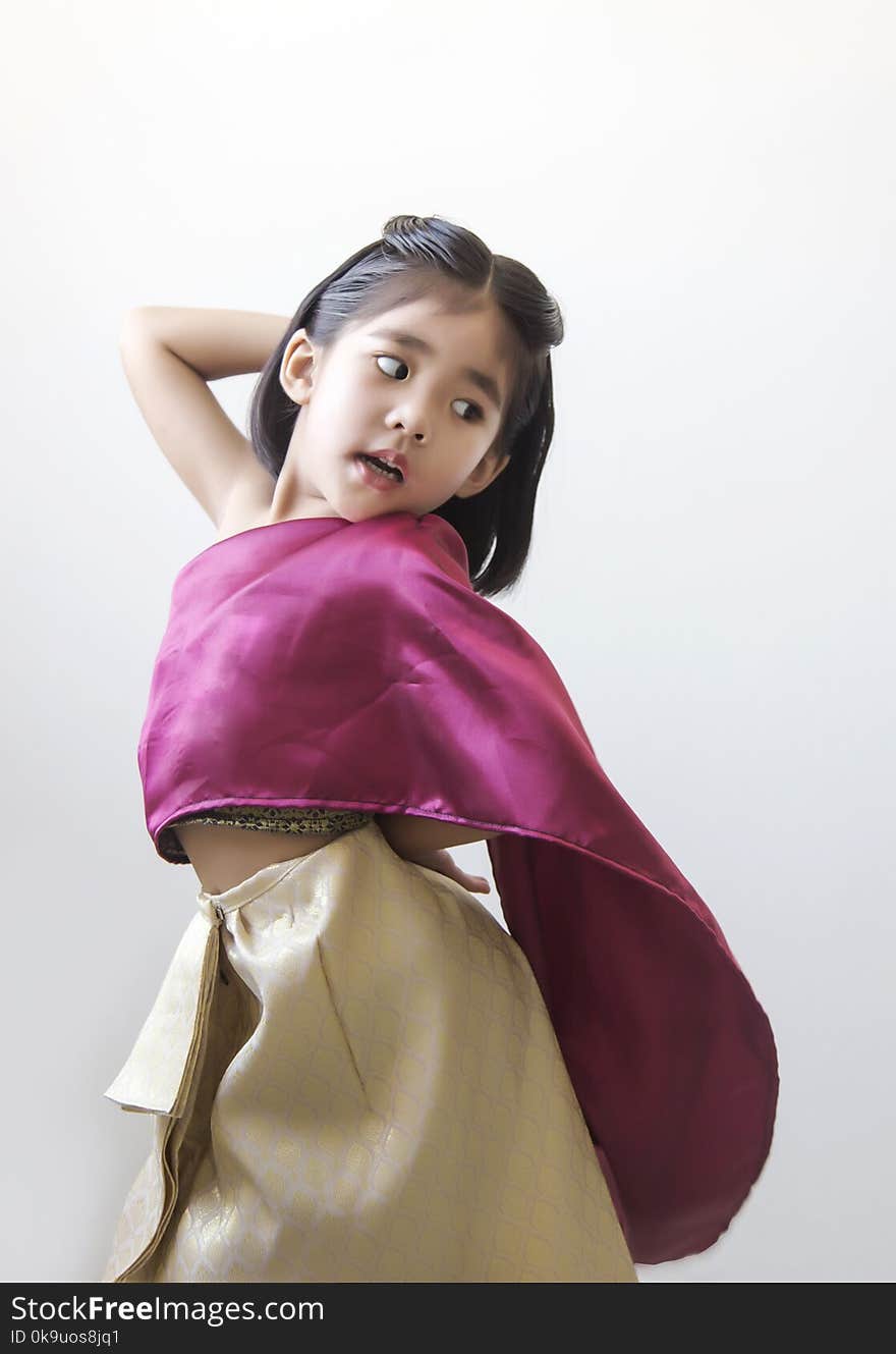 Thai kid funny action showing with hand on white. Thai kid in tradition Thai dress costume on white background