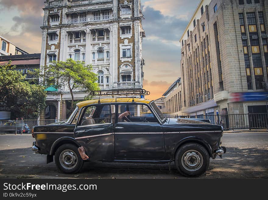 Mumbai taxi on the city street on the background of houses. Mumbai taxi on the city street on the background of houses