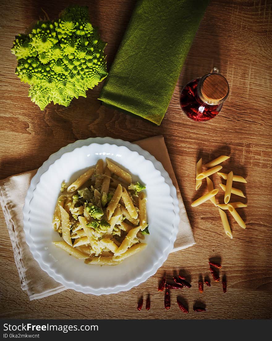 Pasta and roman cauliflower on a wooden table