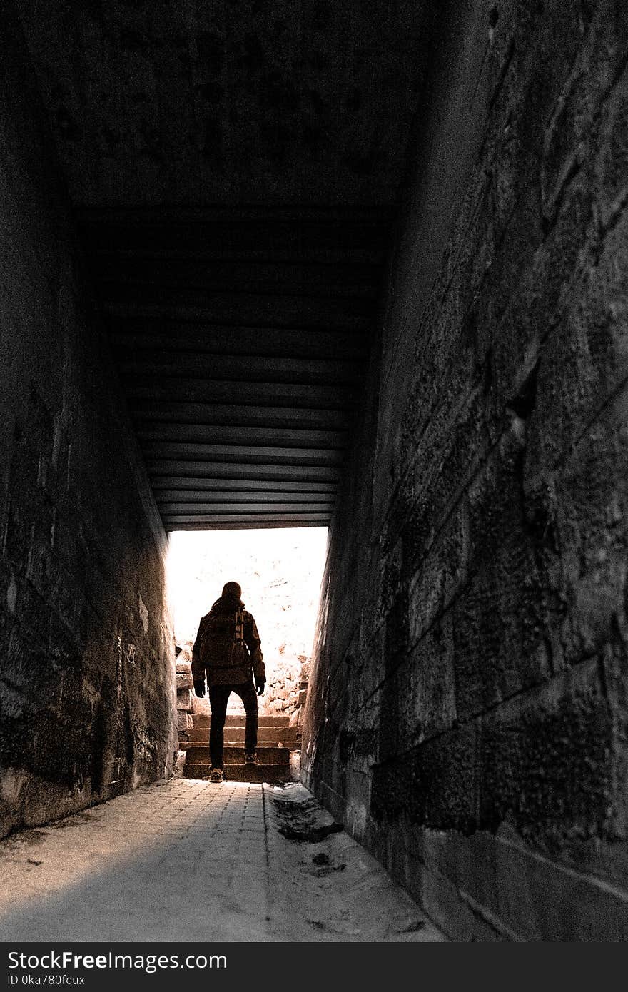 Man in Brown Jacket and Pants Near Gray Alley