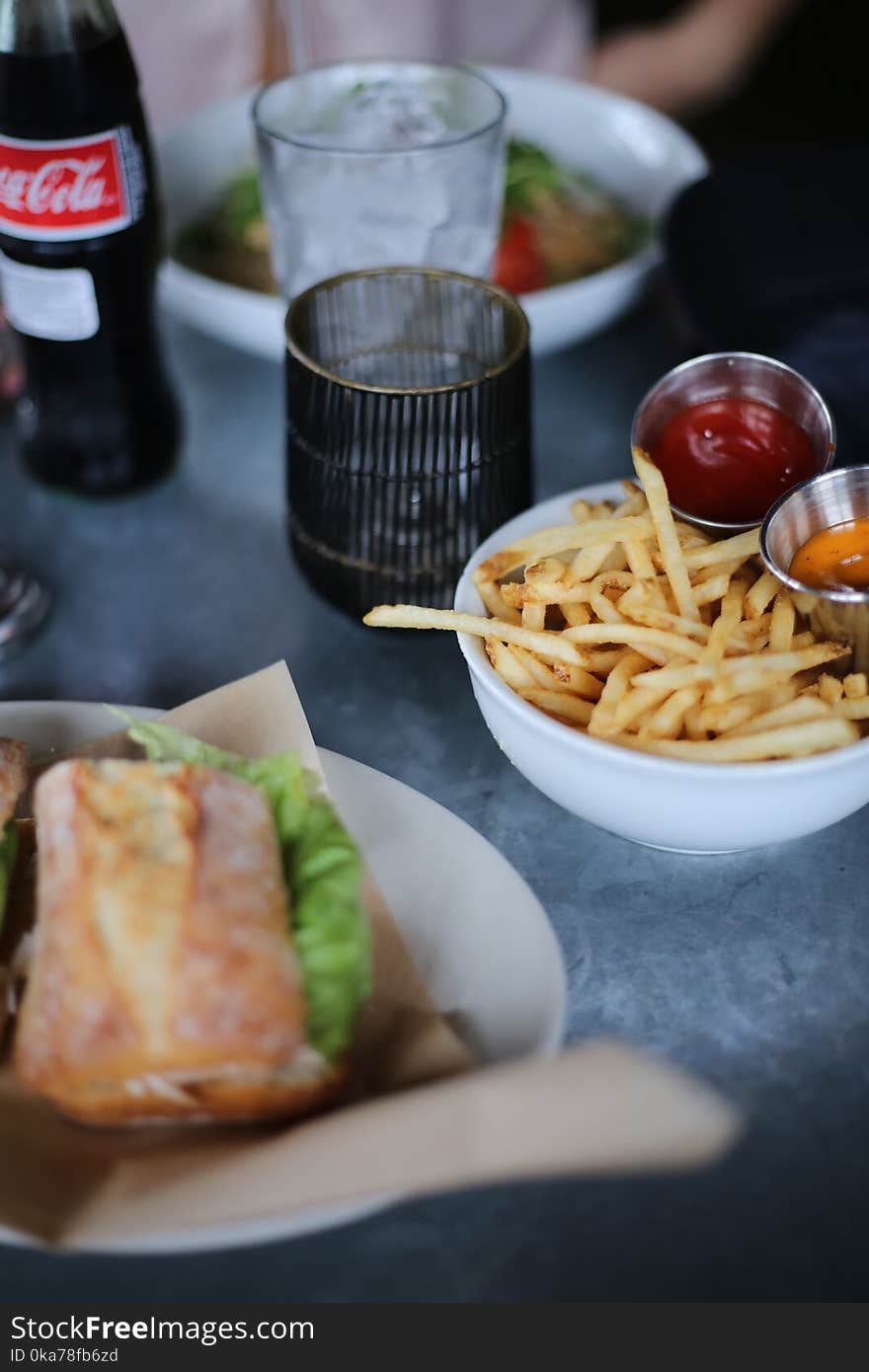 French Fries and Clear Glass Cup on Top of Table