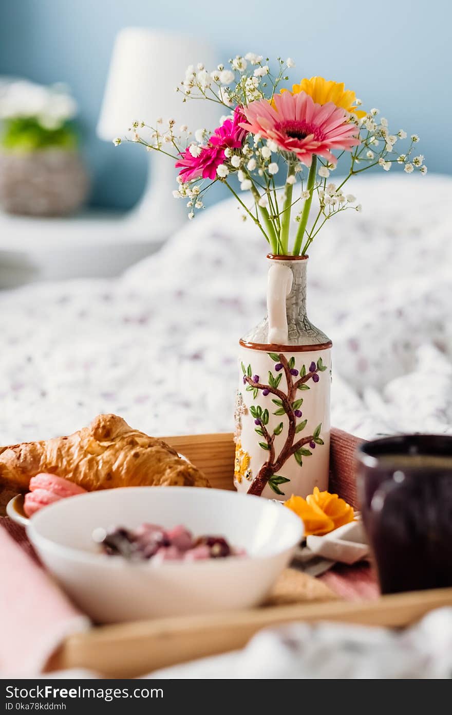 Pink and Yellow Flowers in White and Purple Ceramic Vase Near White Ceramic Bowl