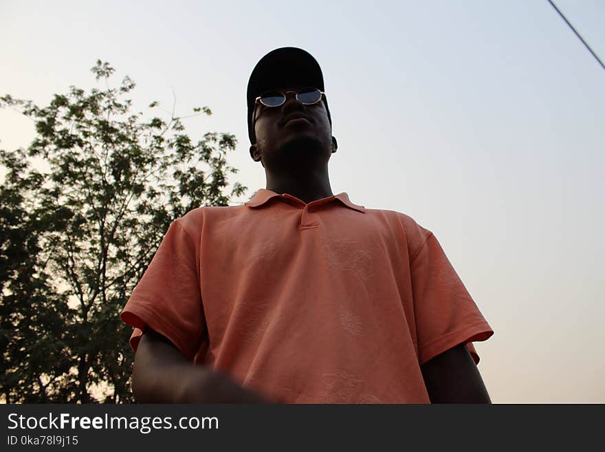 Man in Pink Polo Shirt Standing Near on Green Tree