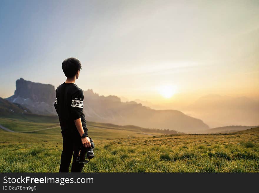 Sepia Photography of Man Wearing Black Sweatshirt Holding Camera