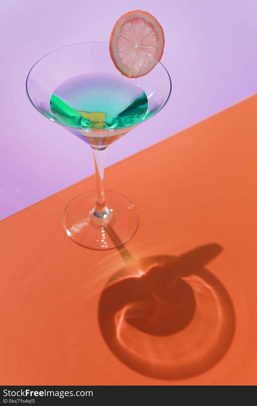 Clear Cocktail Glass On Orange Surface