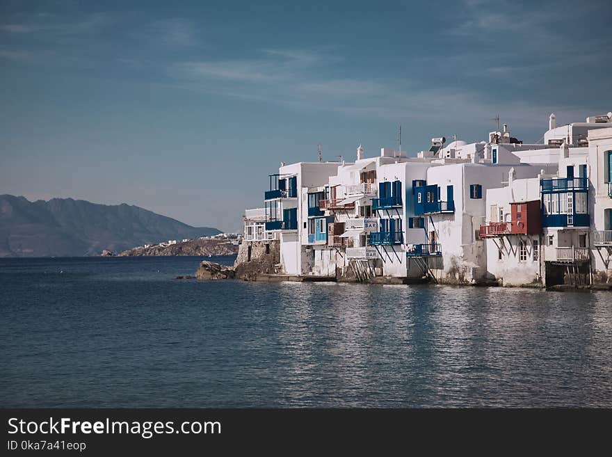 Photo Of White Concrete Buildings Near Body Of Water