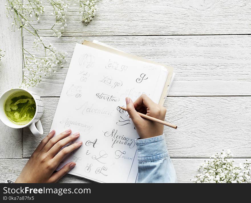 Person Holding Pencil Writing On a Paper