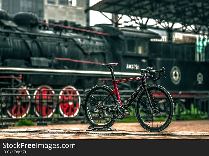 Black And Red Road Bike Near Black Train